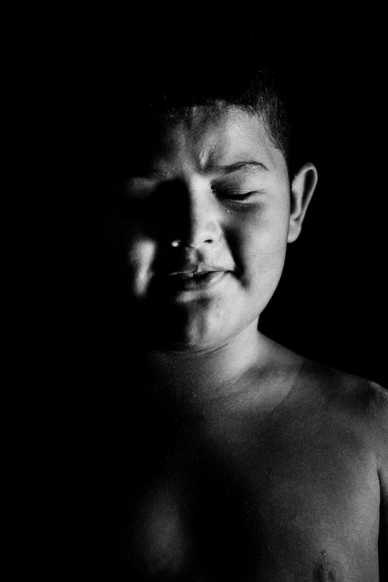 Eyes Closed Portrait of a Child from Ilha dos Lençóis: Black and White Portrait Photography by Jean Tran and Élysée Lang